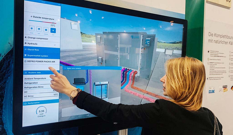 Blonde young woman using interactive 3D manufacturing app on large touchscreen device